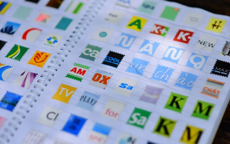 A vibrant mix of colorful stamps displayed in a spiral notebook, showcasing diverse design elements.