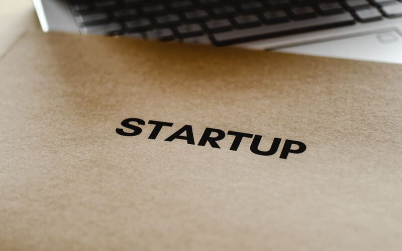 Close-up of a startup folder and laptop, representing business and technology innovation.